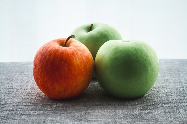 Photo of a green apple next to a red apple on a table taken by Benjamin Wong